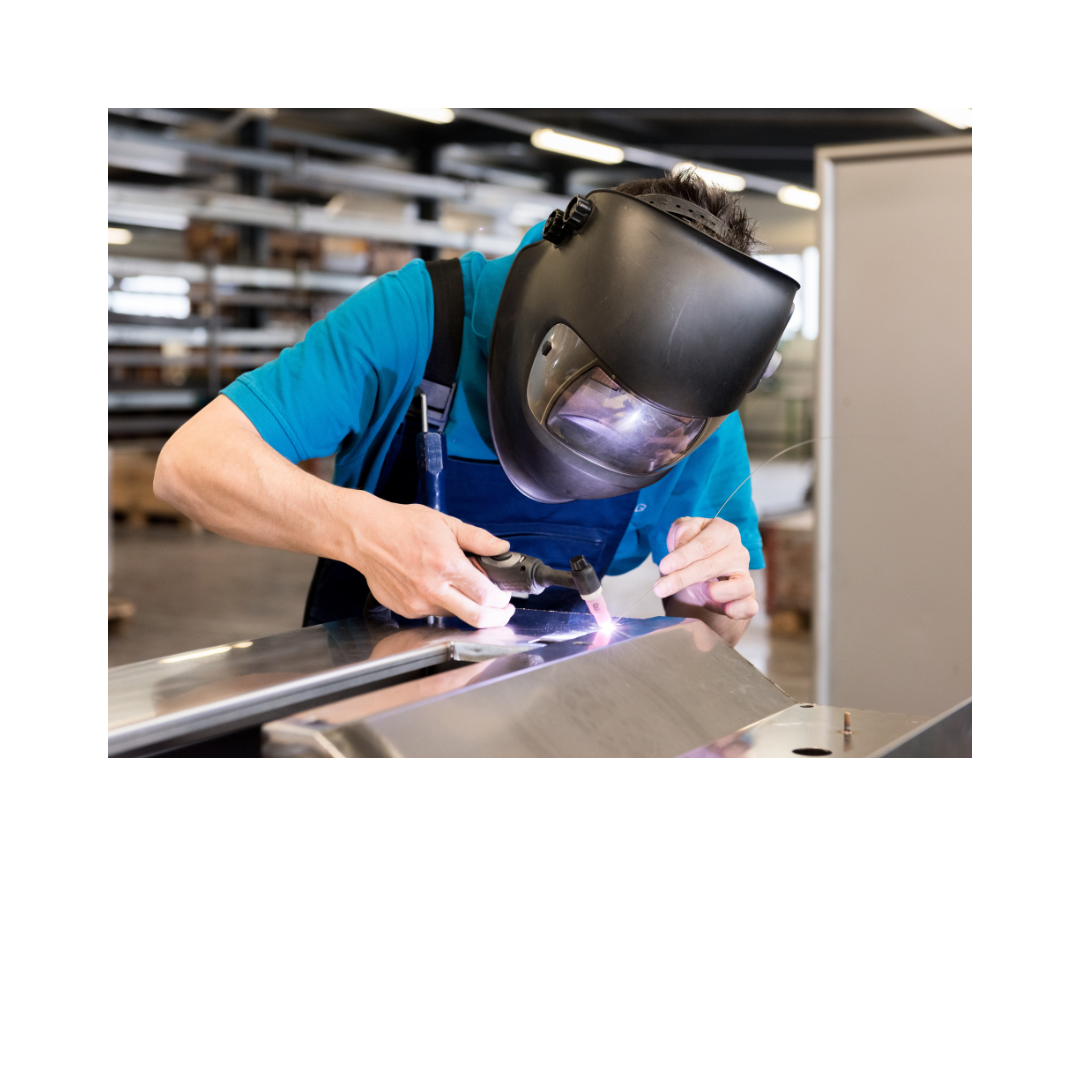 Professional welder in protective gear performing precision welding work